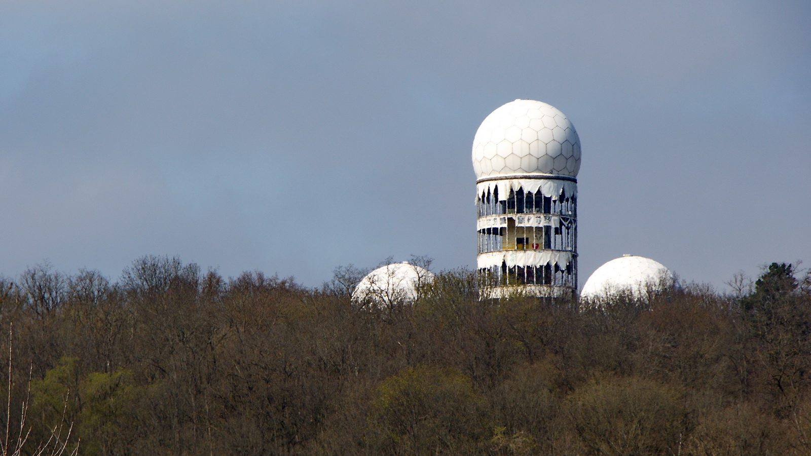 21. April 2023, Blick zum Teufelsberg, auf dem Berg befinden sich die markanten Bauten einer Flugberwachungs- und Abhrstation der US-amerikanischen Streitkrfte.
Nach dem Abzug der Militrs wurde die Anlage von 1991 bis 1999 als Flugsicherungsradar-Station genutzt. Seitdem  verfallen die Gebude. 


 