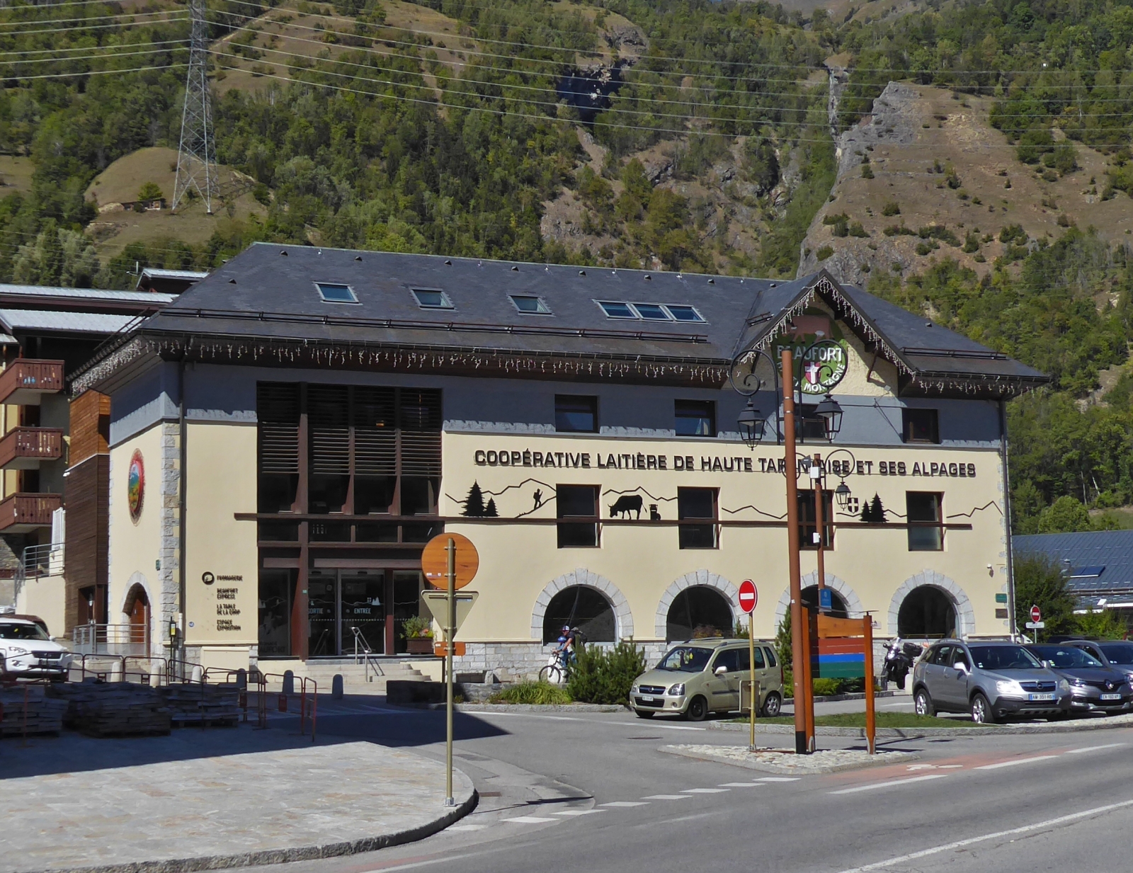 Das Gebude der Molkereigenossenschaft Haut Tarentaise Bourg Saint Maurice liegt gegenber vom Bahnhof, beherbergt neben einer Ausstellung zur Herstellung von Beaufort Kse auch ein Geschft um Lokale Produckte zu kaufen. 09.2022