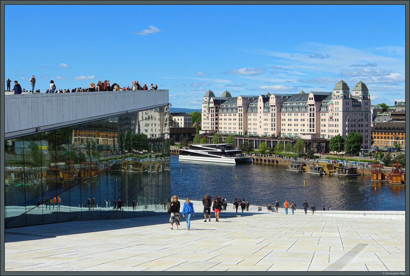 Das Opernhaus von Oslo ist mit seinem begehbaren Marmordach ein touristischer Hotspot. Das Gebude wurde 2008 erffnet und gilt als grtes norwegisches Kulturprojekt. Rechts ist der 1921 errichtete Hafenspeicher zu sehen, heute ein Brogebude. (Oslo, 28.05.2023)