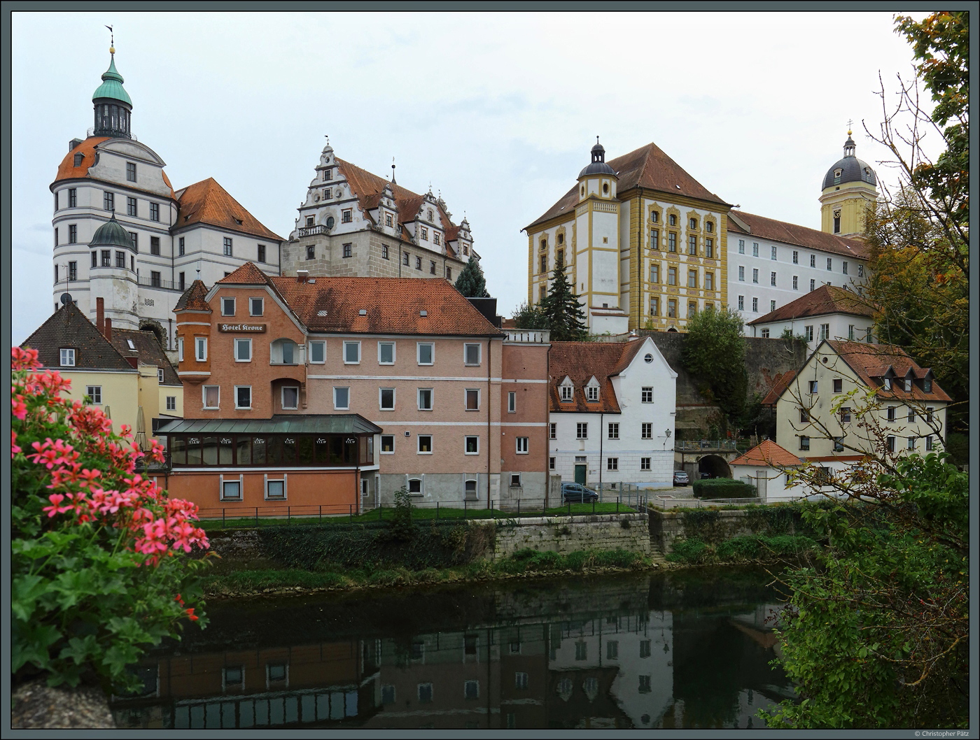 Das Stadtschloss von Neuburg war Residenz fr das Herzogtum Pfalz-Neuburg und liegt auf einem Hgel oberhalb der Donau. Die heute sichtbaren Teile des Schlosses (linke Bildhlfte) entstanden weitgehend im 16. und 17. Jahrhundert. Heute befinden sich verschiedene Museen in den historischen Gebuden. Rechts erhebt sich die 1712-1715 errichtete Amalienschule, davor der 1531 erbaute Wasserturm. Am rechten Bildrand ist noch der Turm der Hofkirche Unserer Lieben Frau zu sehen. (09.10.2023)