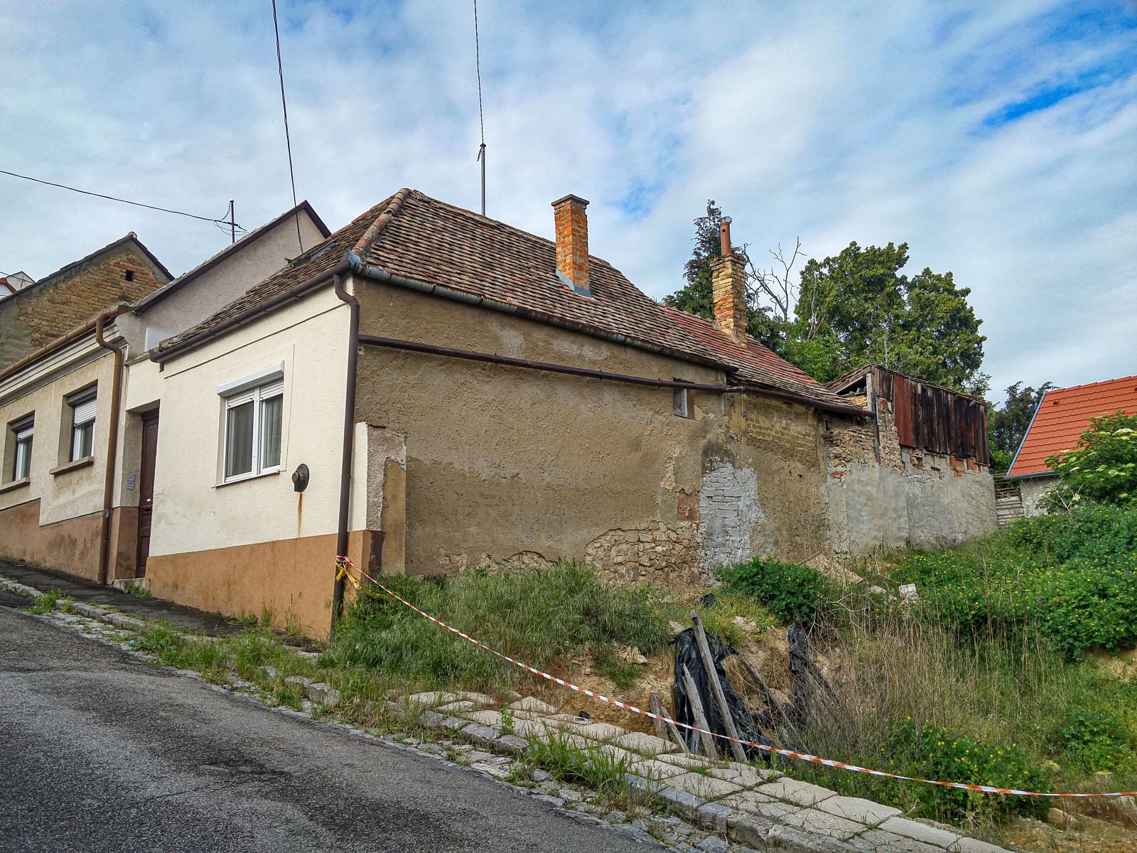 Ein altes Haus und ein Lckengrundstck in Pcs, fotografiert in Mai, 2021
