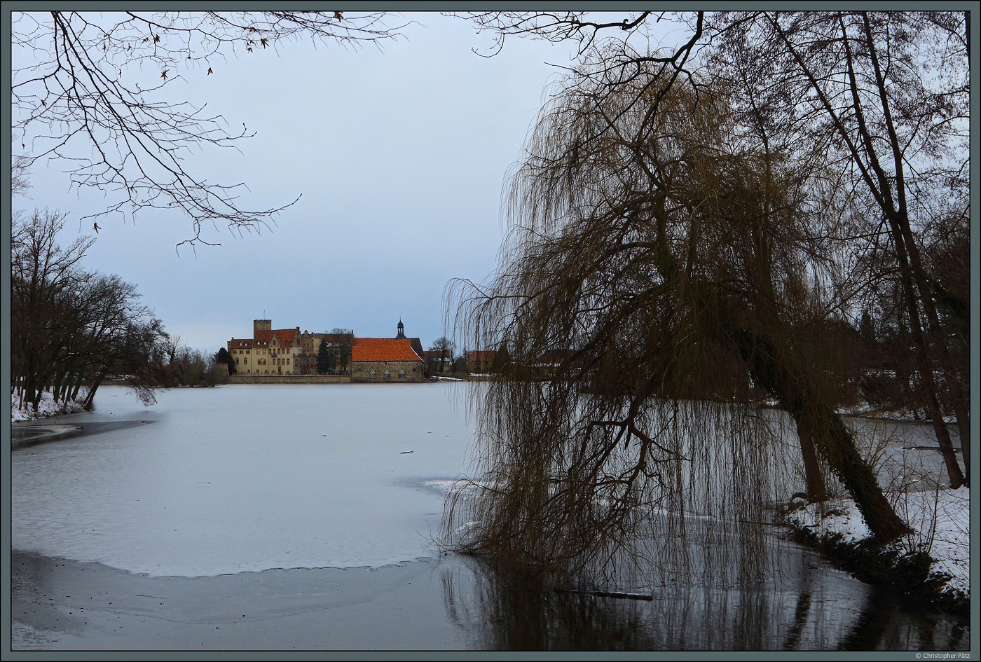 ber zugefrorenen Schlossteich fllt am 21.01.2024 der Blick auf die Wasserburg Flechtingen.