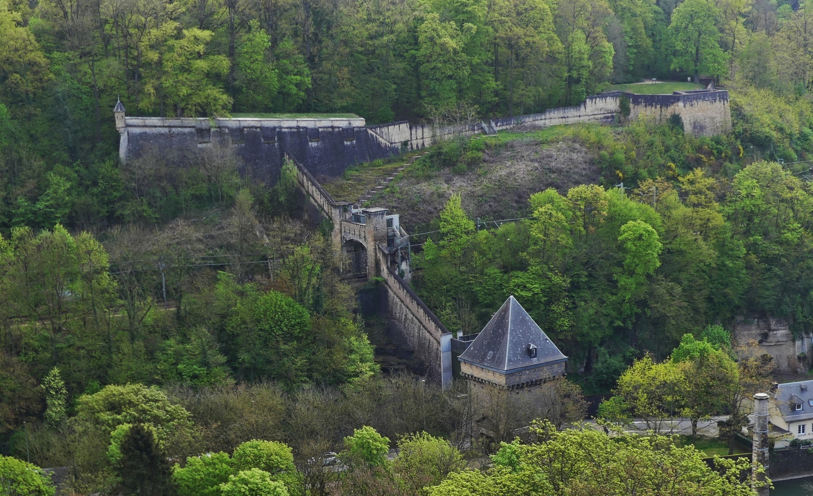 Vauban Turm im Pfaffennthal, Stadtteil der Stadt Luxemburg, von der Roten Brcke (Pont Grand Duchesse Charlotte) ausgesehen.
Der Verbindungsweg fhrt zu den 3 Eicheln, (Fort Thringen, in dem das Muse d’Art Moderne Grand Duc Jean untergebracht ist). 
Die Mauern am rechten Bildrand gehren zum Fort Niedergrnwald. 04.2024

