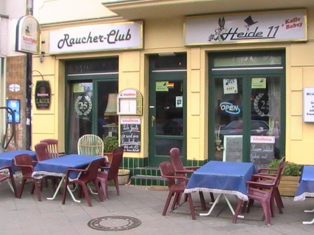 Am 1.1.2008 wurde in Berlin und den meisten anderen Bundeslndern das Nichtraucherschutzgesetz eingefhrt. Dieses verbietet das Rauchen in ffentlichen Rumen, was auch Restaurants, Kneipen und Bars betrifft. Es darf einen Raucherraum geben, darin darf allerdings nicht bedient werden - das Nichtraucherschutz dient dem Schutz der Angestellten. In Berlin gibt es die Besonderheit, dass Bugelder erst ab 1.6.2008 fllig werden. Das fhrt dazu, dass einige Restaurants und die meisten Bars und Kneipen das Verbot bisher ignorieren. Insbesondere Kneipenwirte frchten um ihre Existenz, wenn sie das Verbot umsetzen mssen - krzlich gab es eine Demonstration gegen das Rauchverbot. Im Bild zu sehen der Raucher-Club Heide 11 an der Hasenheide in Berlin. Ob dieser Trick der Umgehung des Rauchverbotes haltbar ist, ist fragwrdig. Langfristig werden sich die gesellschaftlichen Gepflogenheiten wohl den Gesetzen anpassen mssen, was fr die einen eine Verschlechterung, fr die anderen eine Verbesserung ist.