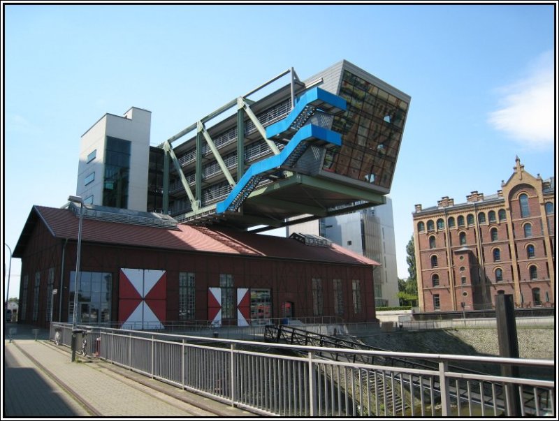 Am sdlichen Ende des zum Medienhafen gehrenden Hafenbeckens  findet man den  Wolkenbgel , der quer ber ein altes, denkmalgeschtztes Hafengebude gebaut wurde. In dem alten Gebude befindet sich eine Diskothek, in dem Baukrper darber u.a. Bros. (15.07.2007)