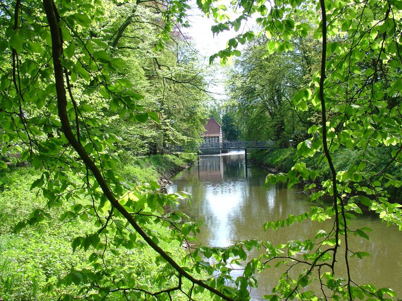 Anfang Mai 2008 wurde dieses Motiv mit der alten Schlossmhle am Wasserschloss Rheda aufgenommen. In der Mitte des Bildes ist die neue Emsbrcke zu erkennen, welche eine neue Verbindung zum Schlosspark Rheda erffnet.