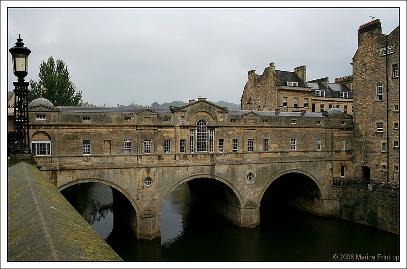 Bath - Pultney Bridge.  Die von Lden gesumte Brcke im palladianschen Stil, die weitgehend nach den Plnen von Robert Adam restauriert wurde, war ein wichtiger Faktor in den Plnen der Pultneys, ihr Land am anderen Flussufer zu erschlieen. Adams schwebten beim Entwurf der Ende 1773 fertiggestellten Brcke ganz offensichtlich Ponte Vecchio und die Rialto-Brcke vor.  Quelle: Pitkin Stadtfhrer Bath