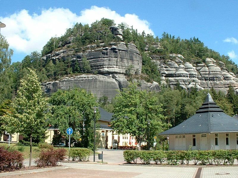 Berg Oybin vom zentralen Parkplatz in der Ortsmitte von Kurort Oybin im Zittauer Gebirge im Juli 2003, hinter den Bumen das Hotel Oybiner Hof.