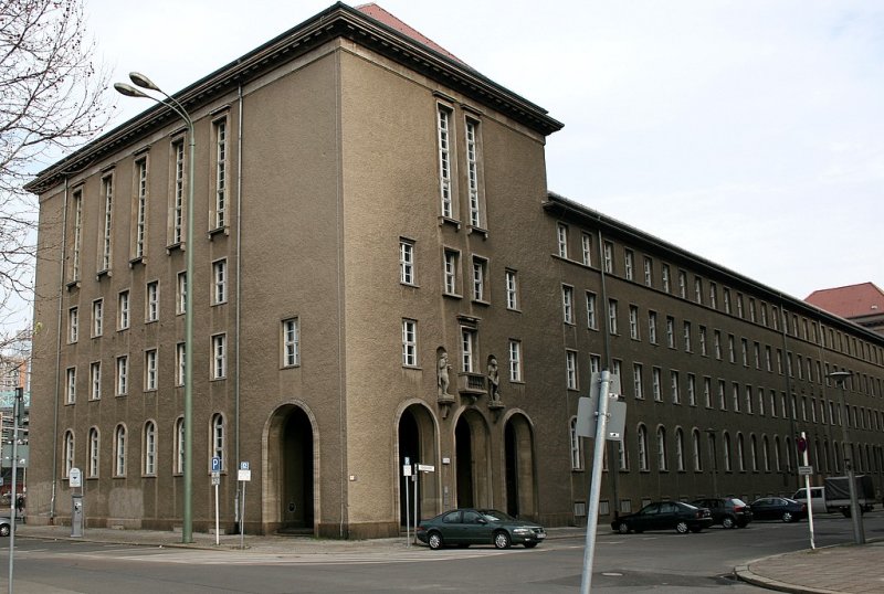 Berliner Architektur 1933-45: Neue Stadthaus. Arnous und Strack bauten dieses 4geschossige Haus, der von zwei hheren Kopfbauten eingefasst wird. Es hat eine schlichte Putzfassade mit werksteingerahtmen Fenstern. Hinter den Arkaden der Kopfbauten liegen die Eingaenge. Skulpturen an den Balkonen weisen auf die Aufgaben einer Versicherung hin (vorgesehen war das Gebude fr die Feuersozietaet)- eine Frau die ihre Hand ber ein Haus hlt und ein Mann der Wasser ber ein brennendes Gebude schttet. Seit 1945 sind Behrden der Stadtverwaltung hier untergebracht, 1948 sprengten kommunistische Demonstranten die Sitzung der freien Versammlung und machten die Weiterarbeit unmglich und zerstrten so die politische Einheit Berlins.