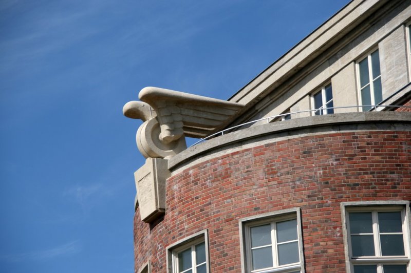 Berliner Architektur 1933-45: Reichsbahndirektion. Von Armin Wegener schon 1895 gebaut sieht man auf der Rckseite des Gebudes, direkt auf die Hochbahn, die heutige U3, blickend auf einem steinernen Sockel das Emblem der Bahn: Dynamisch geformte Adlerschwingen auf einem Eisenbahnrad. In dem Relief darunter war ein Hakenkreuz,das nach dem Krieg entfernt wurde.