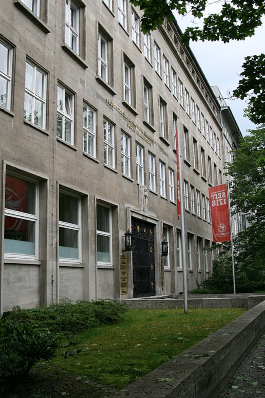 Berliner Architektur 1933-45:Feuersoziett der Provinz Brandenburg. Das 1936 errichtete Stahlskelettgebude hat eine zweckmssige Architektur. Es ist mit Werkstein verkleidet,hat kantige Fensterrahmen und kunsthandwerkliche Ausstattungen (Eingangsportal!). Die Fassade ist dreigeteilt mit EG,Mittelbereich und abgesetzten Attikageschoss. Am Bauvorhaben waren zahlreiche Handwerker beteiligt: Bildhauer,Glasmaler, Kunstschmiede..Das schne schmiedeeiserne Gitter des Eingangs zeugt heute noch davon. Selbst Speer wollte bei seinem grssenwahnsinnigen Vorhaben die NordSued Achse zu bauen dies Haus erhalten und auf einen anderen Platz versetzen.