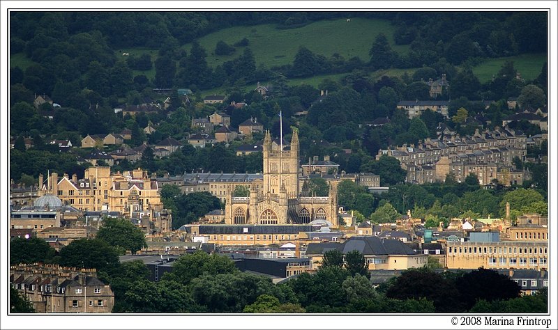 Blick auf Bath und die Westfassade der Abbey.  Die Abteikirche Bath (engl. Bath Abbey) ist eine Pfarrkirche in Bath, England, die einst die groe Kirche eines Klosters war. Sie wurde im Jahr 1156 fertiggestellt. Die Abteikirche Bath wurde im 13. Jahrhundert stark beschdigt und im 16. Jahrhundert wiederaufgebaut... Die Abtei ist 67 m lang und 22 m breit, einschlielich der Seitenschiffe. Das Hauptschiff ist 24 m und der Turm 49 m hoch. Das groe Fenster ber dem Hochaltar zeigt 56 Szenen aus dem Leben Jesu Christi.  Quelle: Wikipedia