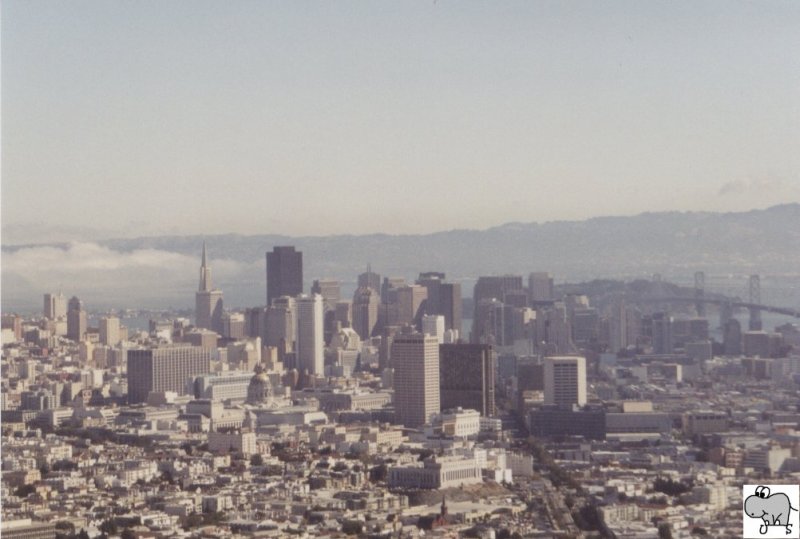 Blick auf den Financal District von San Francisco. Hinten Rechts ist die Oakland Bay Bridge zu erkennen, wogegen die Golden Gate Bridge links im Nebel verschwunden ist. Die Aufnahme entstand von den Twin Peaks aus am 06. September 2002.