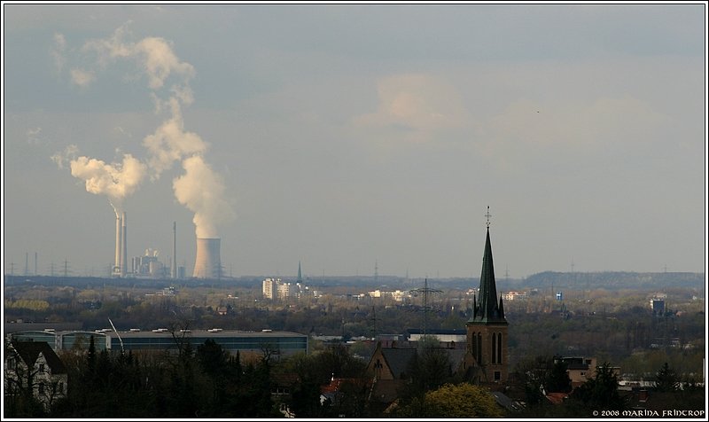 Blick vom Bismarckturm ber Mlheim an der Ruhr - Im Vordergrund die Evangelische Kirche an der Wilhelminenstrae in Broich. Im Hintergrund das HKW Voerde (Luftlinie ca. 22 km).