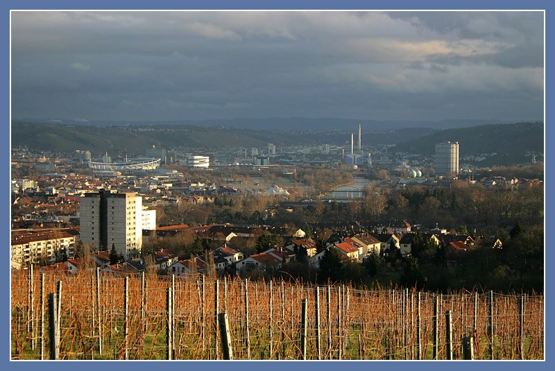 Blick vom Burgholzhof ins Stuttgarter Neckartal im letzten Sonnenlicht vor einer Schlechtwetterphase. Markante Punkte sind das Daimler-Stadion und das Mercedes-Benz-Museum links, das Kraftwerk Gaisburg rechts der Mitte und der Gaskessel in Gaisburg links. Im Hintergrund ist die Schwbische Alb erkennbar. 4.1.2007 (Matthias)