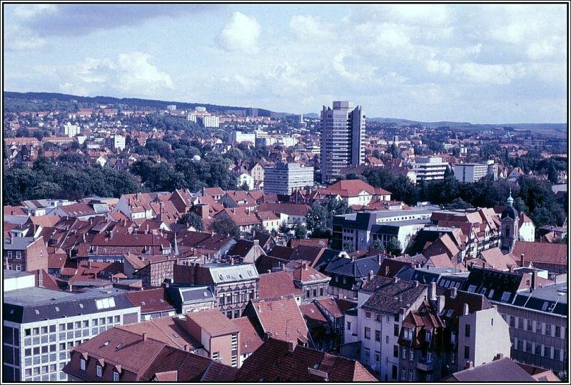 Blick vom einem der Trme der Johanniskirche ber die Gttinger Innenstadt in sdstliche Richtung. Im Zentrum des Bildes der Turm des neuen Rathauses. Dieses Bild wurde etwa Mitte der 80er Jahre des vergangenen Jahrhunderts von meinen Vater Alfred Schmidt aufgenommen; es handelt sich um den Scan eines Dias. Seitdem hat es aber keine wirklich gravierenden nderungen gegeben, die das Stadtbild wesentlich verndert haben.