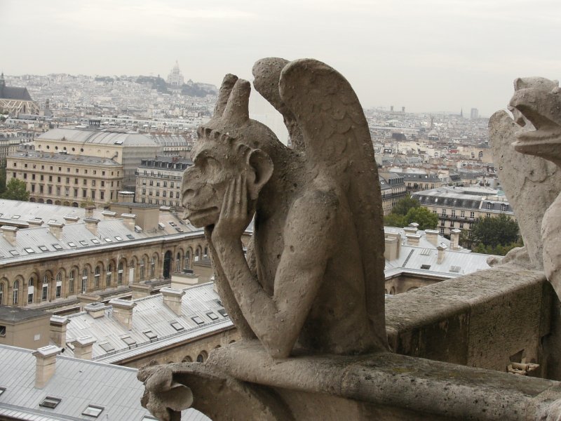 Blick von der Kirche Notre Dame in Paris auf die Basilique du Sacr-Cur auf dem Montmartre. Gesehen am 09.10.2006. Hier der Blick auf eine sogenannte Groteske (Steinfigur) aus der  Galerie des chimres . Es handelt sich hier um Fabelwesen, die Unheil abwenden sollen.
