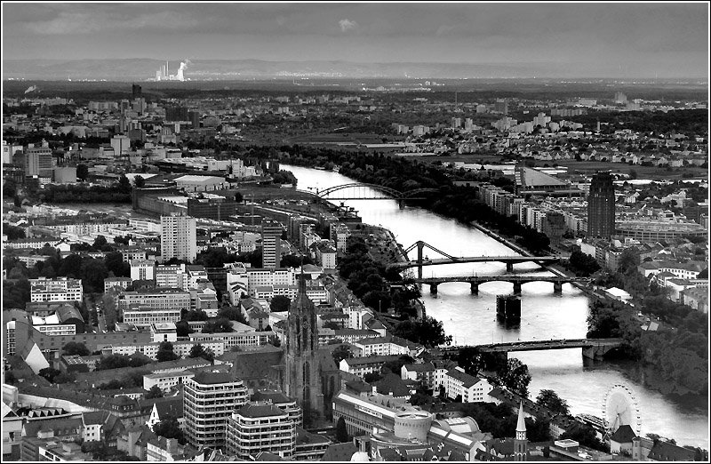 Blick vom Maintower nach Osten ber den Dom (unten in Bildmitte) zum von der Sonne angestahlten Kraftwerk Staudinger sdlich von Hanau im Hintergrund. Die Mainbrcken von unten nach oben: Alte Brcke, Obermainbrcke, Neue Flerbrcke, Deutschherrenbrcke. Der Hhenzug im Hintergrund ist der Spessart. 1.6.2006 (Matthias)