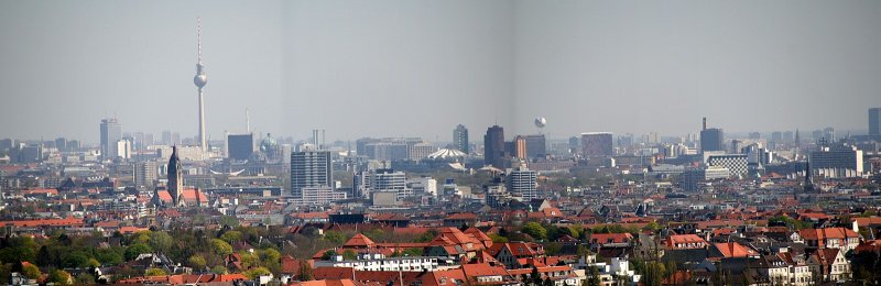 Blick vom Messeturm zum Osten. Stark herangezoomt, deshalb die schwarzen Rnder. Zu sehen ist der Funkturm am Alex, links daneben das Park Inn Hochhaus. Rechts daneben das Handelzentrum mit der schwarzen Frontverkleidung. Davor die Kuppel des Reichtags und daneben der Dom. Fast in der Mitte das Sony Center und die Hochhuser am Potsdamer Platz. Der Ballon daneben ist der HiFlyer, darunter das Springer Gebude und weiter rechts das GSW Haus mit der bunten Fassade. Weiter rechts das Postbank Gebude, davor das Hotel Interconti und diverse Huser am Bhf Zoo. 
Links im Vordergrund ist das Rathaus Charlottenburg mit seinem markanten Turm.