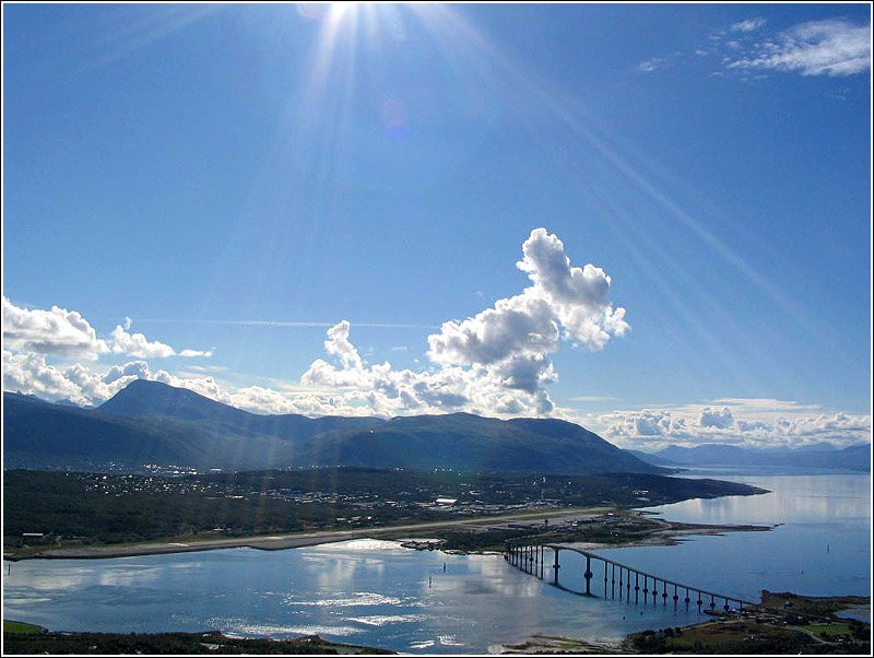 Blick von Nordwesten auf Troms. Im Hintergrund der Hausberg von Troms, der Tromsdalstind. Die Brcke verbindet die Insel Troms mit der groen Insel Kvaly. Erkennbar auch der Flughafen der Stadt. 18.8.2004 (Jonas)