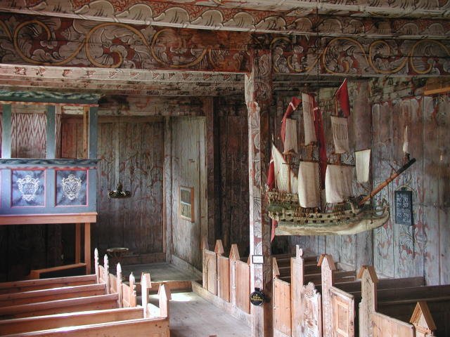 Blick in die Stabkirche von Kvernes. Die Rosenmalereien ist ein typischer Bestandteil der Stabkirchen. Das an der Decke hngende Schiff ist ein typisches Merkmal fr die Kstenregion. Es soll Segen und Schutz fr die Fischer und Seefahrer bringen. 