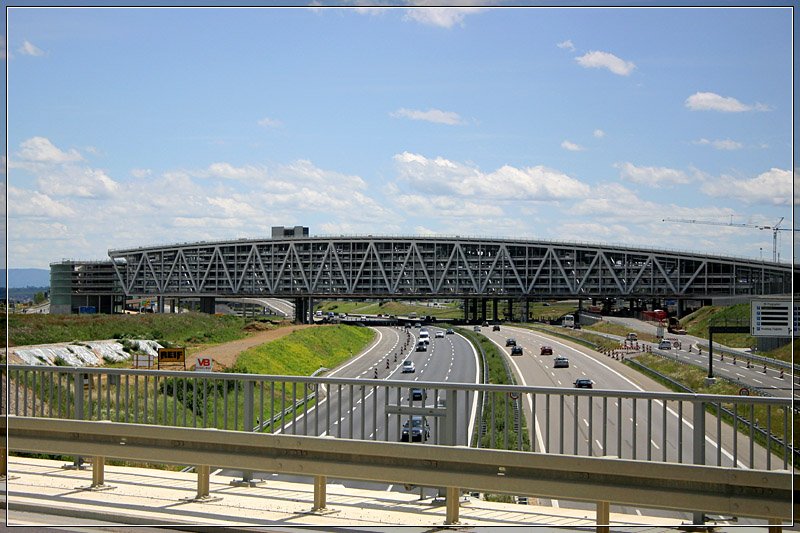 Das neue Parkhaus fr die Landesmesse und den Flughafen wurde in zwei Fingern ber die Autobahn hinweg gebaut. Falls das Bahnprojekt Stuttgart 21 mit ICE-Trasse nach Ulm Wirklichkeit wird, werden die schnellen Zge ebenfalls das Bauwerk unterfahren. Dafr ist die kleinere ffung links neben der Autobahnffnung vorgesehen. 

http://wulfarchitekten.com/portfolio/parkhaus-neue-messe-stuttgart/

24.6.2007 (Matthias)