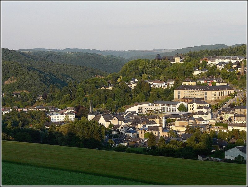 Die Dekanatskirche, der Schulkomplex und das Schloss von Wiltz sonnen sich in der Abendsonne des 12.06.09. Ausserdem ist der Einschnitt des Flusstales der Wiltz zu sehen, wo ebenfalls die Eisenbahnstrecke nach Kautenbach verläuft. (Jeanny)