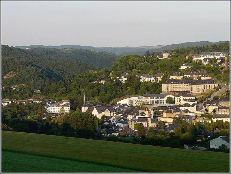 Die Dekanatskirche, der Schulkomplex und das Schloss von Wiltz sonnen sich in der Abendsonne des 12.06.09. Ausserdem ist der Einschnitt des Flusstales der Wiltz zu sehen, wo ebenfalls die Eisenbahnstrecke nach Kautenbach verluft. (Jeanny)