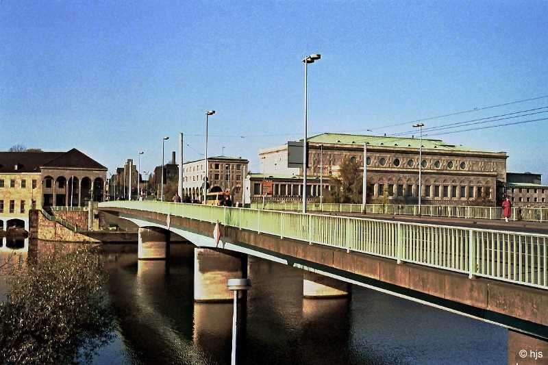 Die Schlossbrcke liegt dem Stadtzentrum am nchsten. Der westliche Brckenkopf wird flankiert von der Stadthalle rechts und der  Wasserburg  (Verwaltungsgebude der Wasserwerksgesellschaft) links (18. November 1989).