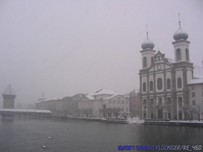 Die verschneite Jesuiten Kirche rechts, Links der der Wasserturm hinter der Kapellbrcke