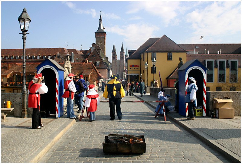 Die Wachposten auf der Alten Mainbrcke in Wrzburg, verlangen hier einen kleinen Obulus beim beequeren des Mains. Der hohe Turm ist der Rathausturm, die beiden Trme in der Straenflucht gehren zum Dom. 25.2.2006 (Matthias)