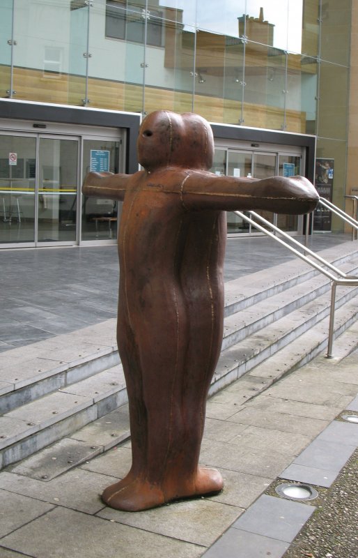 Diese Figur hatte ihren Platz ursprnglich auf der Stadtmauer.
Der Knstler lie sie so aufstellen das man beim Hindurchschauen der Augen jeweils auf den andersglubigen Stadtteil sehen konnte ( Katholisch/Protestantisch). Der Knstler wollte den Menschen bewusst machen das alle eigentlich gleich waren. Es gab einen grossen Eklat deswegen und kurze Zeit spter wurde die Statue von der Mauer entfernt. Sie fristet nun ihr Dasein in einem stillen Strsschen.
(September 2007) 