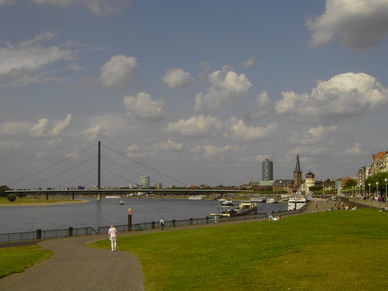 Dsseldorf, Rheinuferpromenade. Im Hintergrund Skyline von Dsseldorf, mit Schlossturm, Kirche St. Lambertus, Victoria-Turm und Oberkasseler Brcke.
Aufgenommen am 21.08.2009.