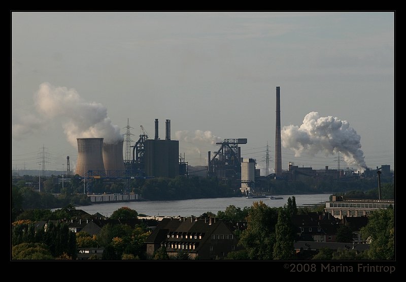 Duisburg - Blick ber Wanheimerort und den Rhein auf die Httenwerke von Krupp-Mannesmann in Huckingen bzw. Httenheim. Aus dieser Blickrichtung vor den beiden Khltrmen sieht man, wo das 4. Duisburger Container-Terminal entstehen wird. Unmittelbar links von dem linken Schiff befindet sich die Einfahrt zum Hafen der Krupp-Mannesmann-Htte.