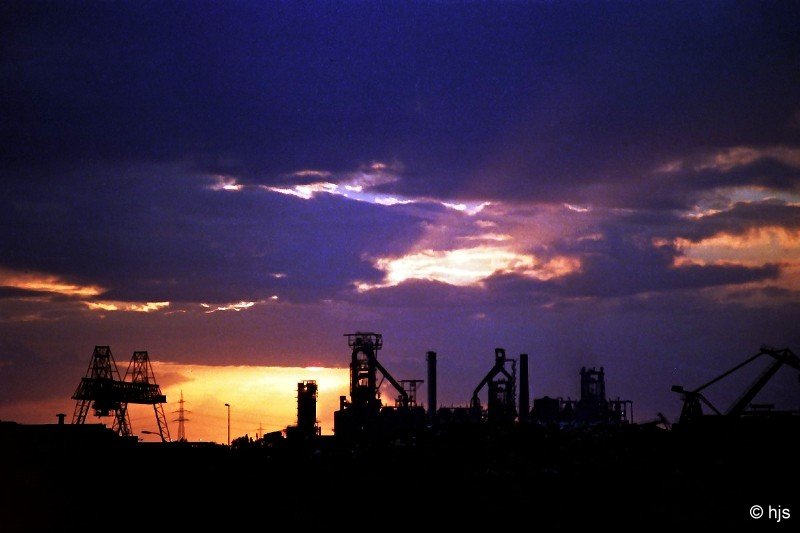 Dunkles Gewlk zieht sich ber dem Stahl- und Httenwerk Ruhrort zusammen (12. Juli 1989). Das Stahlwerk gehrt heute zum Mittal-Konzern, die Hochfen sind verschwunden. Einer hat die Reise nach Indien angetreten, die anderen wurden abgerissen.