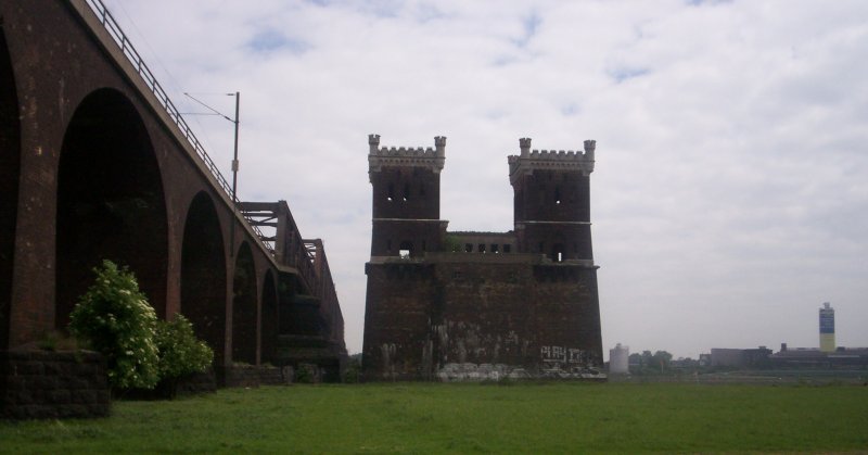 Eisenbahnbrcke mit altem Turm 
Rheinhausen - Hochfeld eine der ersten Eisenbahnbrcken Duisburgs, wurde am 23. Dezember 1873 dem Verkehr bergeben. Der Turm auf der Rheinhausener Seite wurde durch einen gleichen Turm auf der Hochfelder Seite ergnzt. Auf diesen beiden Trmen lag die Brcke ursprnglich auf und zwei Fugngerwege fhrten durch die Trme und ermglichten so die Querung per Pedes.
