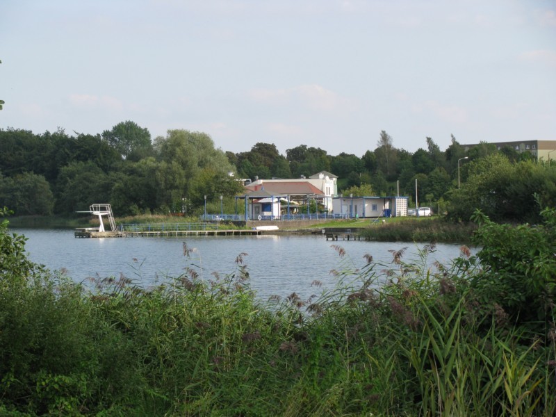 Grevesmhlen, Blick ber dem Ploggensee zum Sdufer mit der Badeanstalt, der Mehrzweckhalle und dem Wohnpark Ploggenseering, 09.09.2008