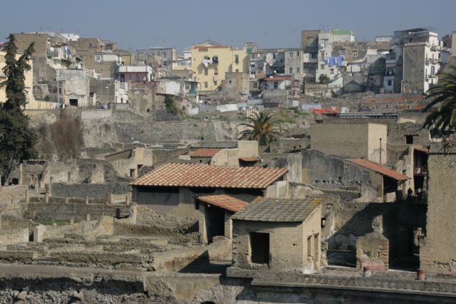 Heute ist gut ein Drittel von Herculaneum ausgegraben und zur Besichtigung freigegeben. Die Bewohner des Stadteils von Ercolano, der direkt ber den Resten von Herculaneum steht, frchten heute um ihre Huser, da sie fr weitere Ausgrabungen weichen mssen. 
Hier der Blick ber die Ruinen der Antike zu den Ruinen von heute. Nur das in den Ruinen von heute noch Menschen leben...