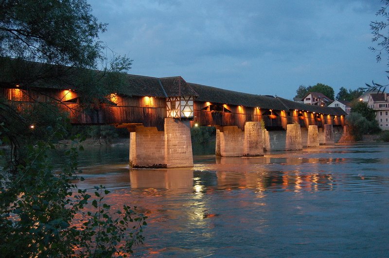 Holzbrücke - Die Lichter der 400 Jahre alten Brücke, nach Plänen des bekannten Brückenbaumeisters Blasius Baldischwiler, spiegeln sich im ruhigen Wasser des Rheins. 7.8.2006