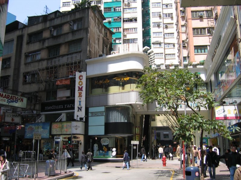 Hong Kong : Baustile alt, tradidionell und neu vereinen sich im bunten Treiben vor dem Eingang zu einer Einkaufspassage