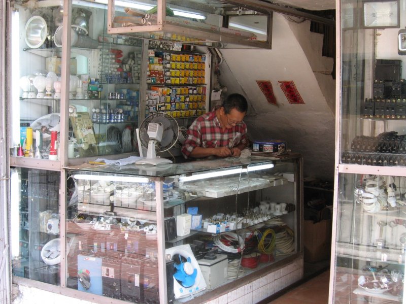 Hong Kong : Raum ist in der kleinsten Htte hat sich der Elektrohndler gesagt und im Hauseingang an der Hennessy Road unter der Treppe sein Geschft eingerichtet. Klein aber fein und platzoptimiert gut sortiert.