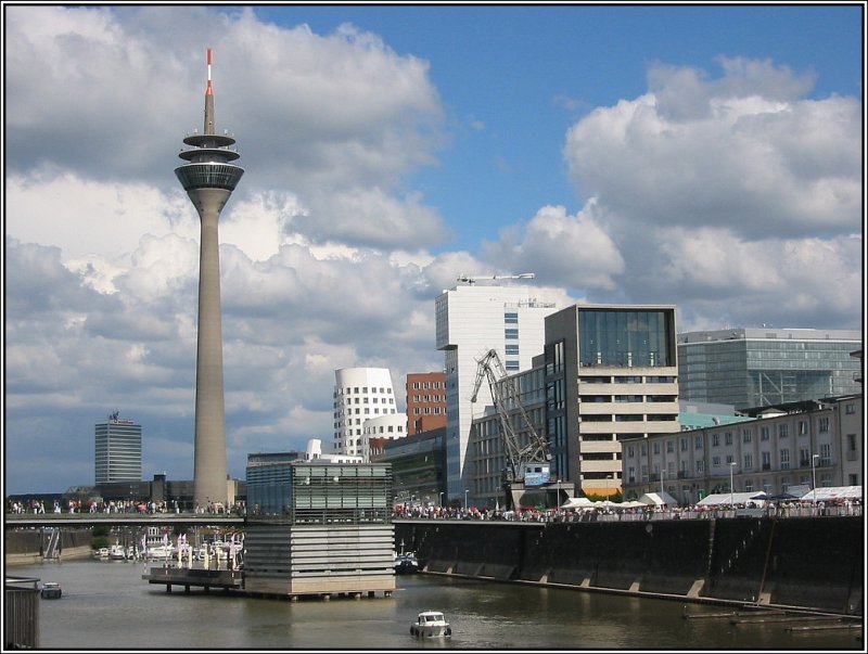 In den 70er Jahren des letzten Jahrhunderts wurde beschlossen, den Dsseldorfer Rheinhafen zu verkleinern und die freiwerdenden Flchen fr eine andere Nutzung vorzusehen. So wurden in den 80er Jahren der Rheinturm, der Landtag und ein Gebude fr den WDR auf dem ehemaligen Hafengelnde gebaut, spter dann weitere Brogebude gerade auch fr Unternehmen aus der Medien-Branche. Vielfach wurde auch die bestehende Bausubstanz weiter genutzt. In dem  Medienhafen  genannten Gebiet findet sich auch viel Gastronomie und kulturelle Einrichtungen, und die weiteren Planungen sehen auch ein Hotel und Wohnbebauung vor. Auf dem Bild geht der Blick vom sdlichen Ende des ehemaligen Hafenbeckens hin zu dem Rheinturm. (13.08.2006) 