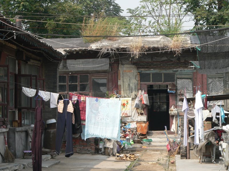 In den Hof geschaut. In Kleinstdten wohnen Chinesen oft in Husern mit einer Etage und einem kleinen Hof. Auch in Peking findet man vereinzelt noch solche Huser, hufig werden solche Stadtbereiche aber abgerissen und mit neuen, greren Husern neugebaut. 09/2007, Shanhaiguan