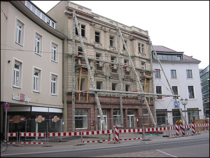 In den Jahren 2003 bis 2005 wurde in Karlsruhe am Rande der Innenstadt ein groes Einkaufszentrum gebaut, fr das eine groe Flche freigerumt werden musste. Im Bild, das am Rondell-Platz aufgenommen wurde, ist u.a. ein Gebude zu sehen, das einst ein kleines Theater beherrbergt hat und desssen Fassade als einziges den Abriss berleben sollte, um in das neue Gebude integriert zu werden. Man kann sehr gut das dazu notwendige Sttzgerst erkennen. (17.05.2003)