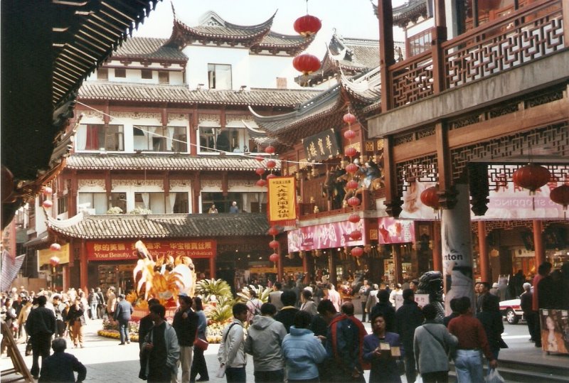 In der neuen  Altstadt  von Shanghai, die den Fußgängern vorbehalten ist, im Juni 2003. Im Zentrum des Bildes auf der rechten Seite in dem etwas niedrigeren Gebäude befindet sich im 1. Stock ein Teehaus, in dem man sich um 100 Jahre zurückversetz fühlt, aber sehr gemütlich