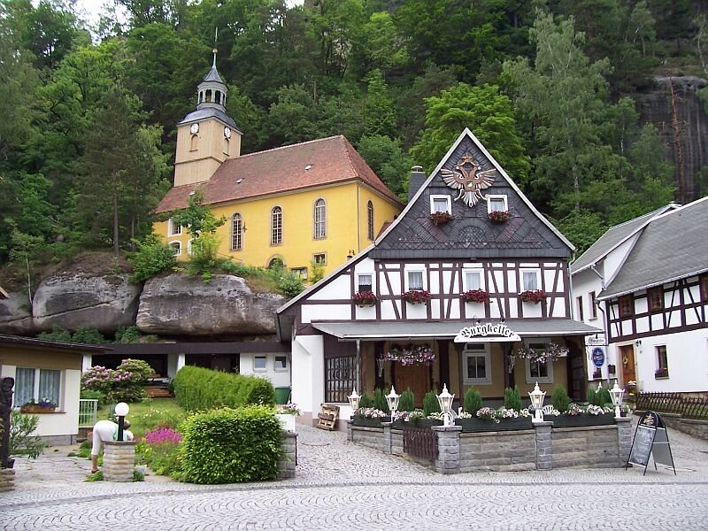 Kirche und Gasthaus Burgkeller in Kurort Oybin im Zittauer Gebirge im September 2006, die Kirche ist innen mit recht alten Wandgemlden ausgestattet. Rechts vom Gasthaus beginnt der Aufstieg zum Berg Oybin.