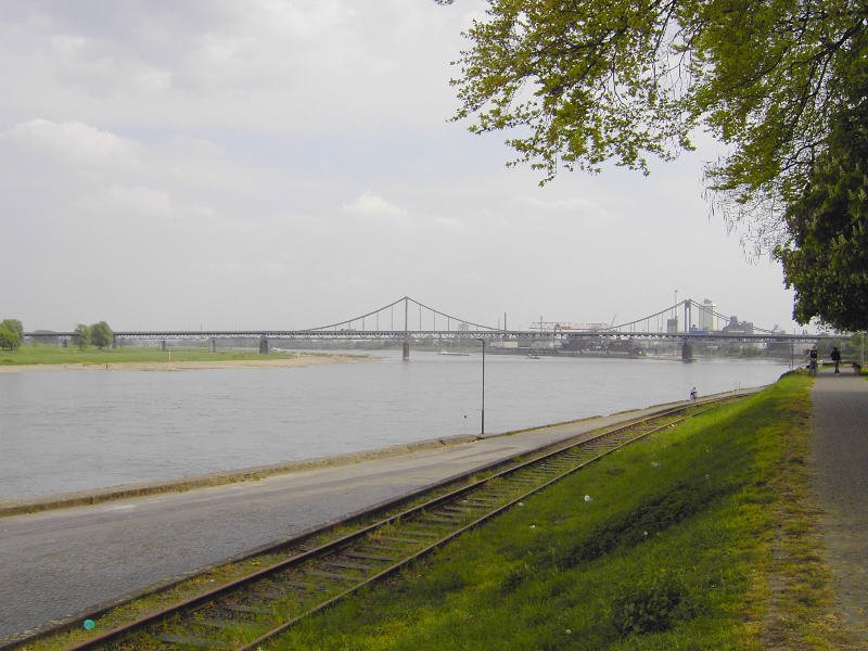 Krefeld-Uerdingen: Bei Stromkilometer 765 verbindet die Rheinbrcke fr Autos (B288 nach Duisburg-Mndelheim) und Fugnger den Linken Niederrhein (*rechts* im Bild) und das Ruhrgebiet. Aufnahme vom Uerdinger Rheindamm (Nhe Am Zollhof) aus, mit Blick auf die Hafeneinfahrt (rechts im Hintergrund). Links geht's stromaufwrts nach Neuss, Dsseldorf und Kln