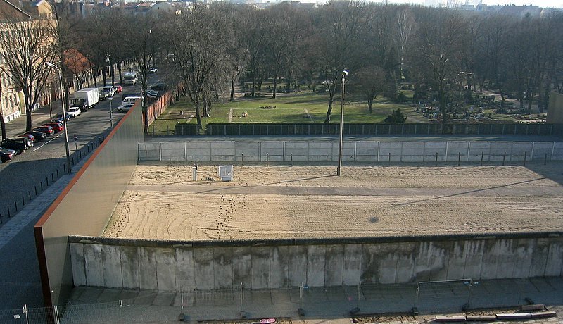 Mauer-Gedenkstaette an der Bernauer Strasse. Im Vordergrund die Mauer gen Westen, dazwischen der Todestreifen mit Gehweg, hinten die Mauer gen Osten.