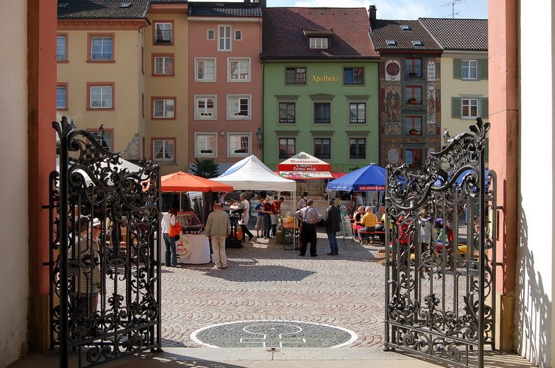 Mnsterplatz - Blick auf den lebhaften Marktplatz durch die schmiedeeisernen Eingangspforten vom Fridolinsmnster. 30.9.2006