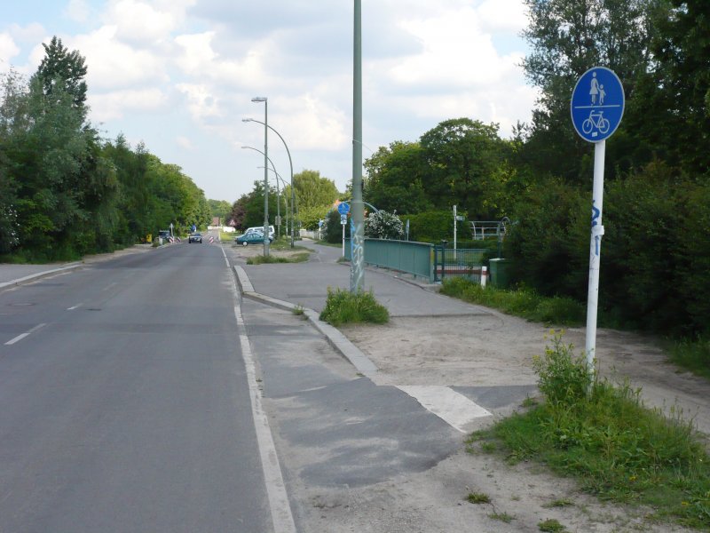 Nett gemeint, falsch gemacht. Der Mauerradweg begleitet hier die Strae Am Brgerpark. Von der Radwegqualitt mal abgesehen verstt die Ausschilderung mit Benutzungspflicht gegen die rechtlichen Grundstze des Radwegbaus. Auf der Fahrbahn fhrt allenfalls jede Minute ein Auto. Hier wre eine freiwillige Variante geeigneter. 31.5.2007